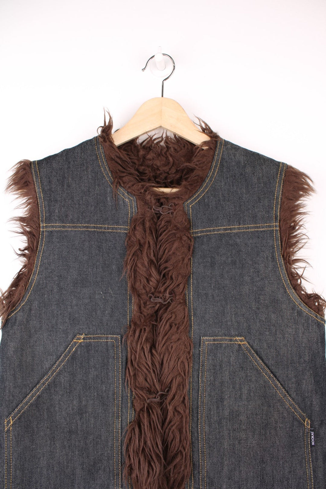 Y2K blue denim vest with brown faux fur lining, two patch pockets and hook closure.