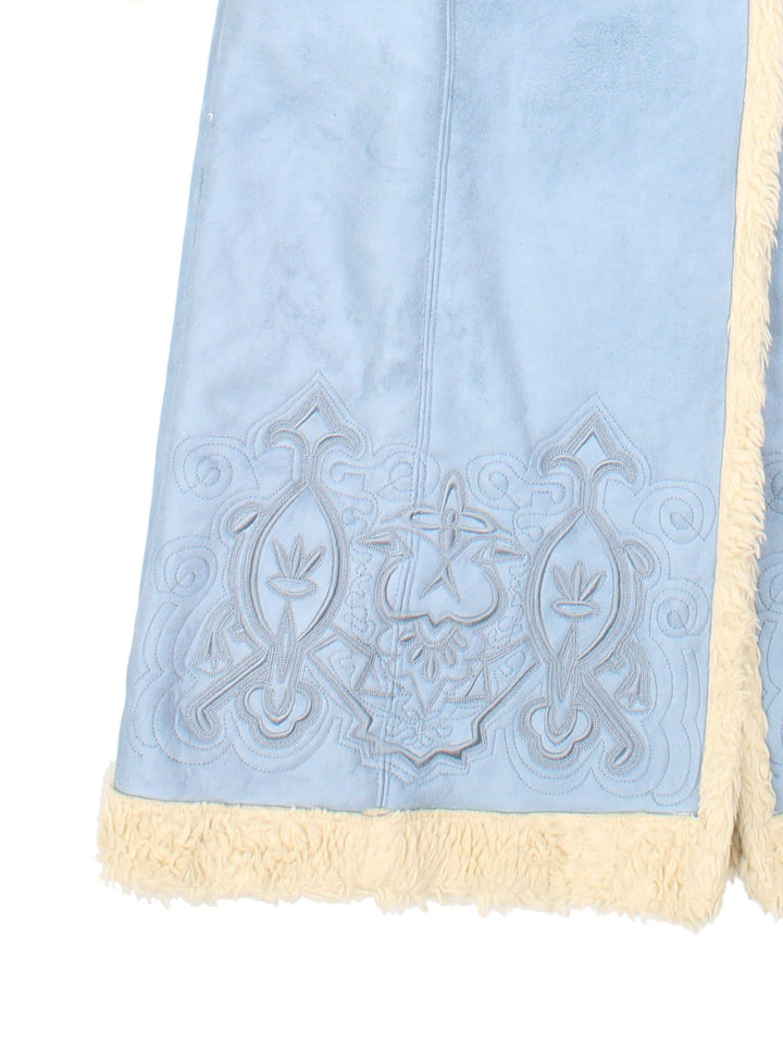 Y2K suede-effect afghan coat in powder blue with sherpa trim, embroidery around the hem and sleeves, two pockets, and button closure, by Centigrade.