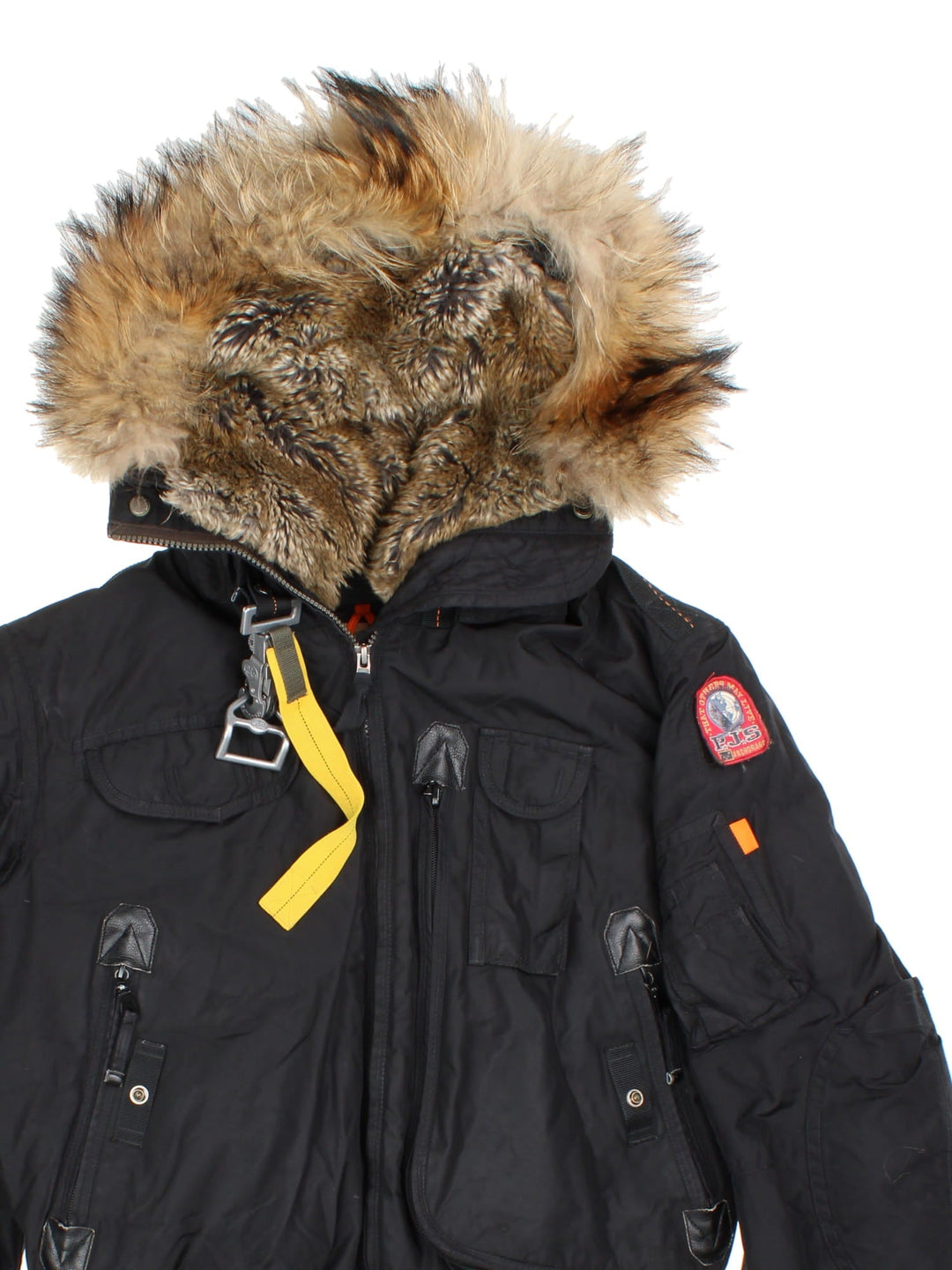 Parajumpers Gobi down coat in black with multiple utility pockets, a velcro logo patch, fur-lined hood, and a PJS carabiner attached.