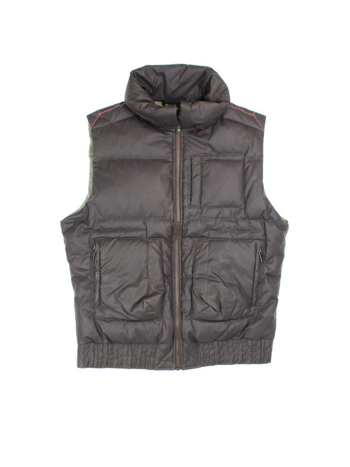 Diesel puffer gilet in brown with three pockets, a branded patch on the back, orange contrast stitching, and zip closure.