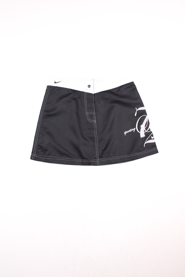 Y2K Nike Sporting Excellence Mini Skirt in black and white colourway with the logo and graphic spell out printed around the left side.