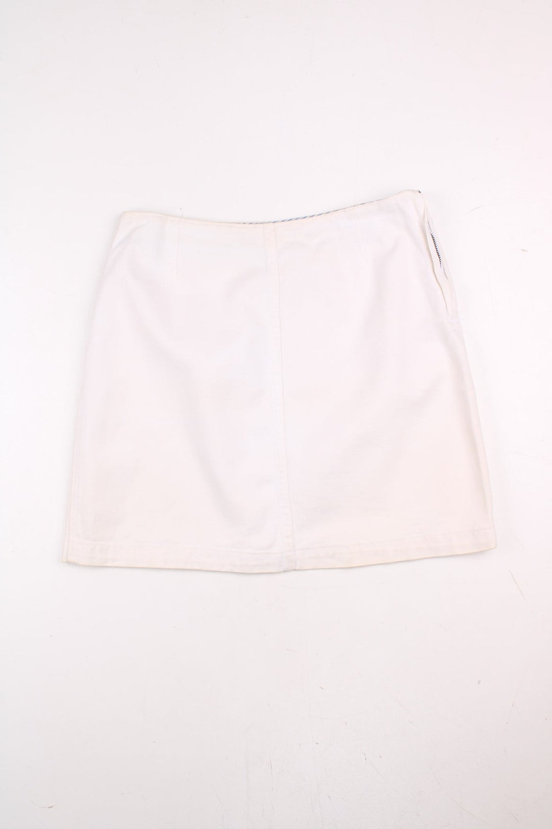 Tommy Hilfiger Mini Skirt in a off white colourway, has zip by the left side and embroidered badge on the back.