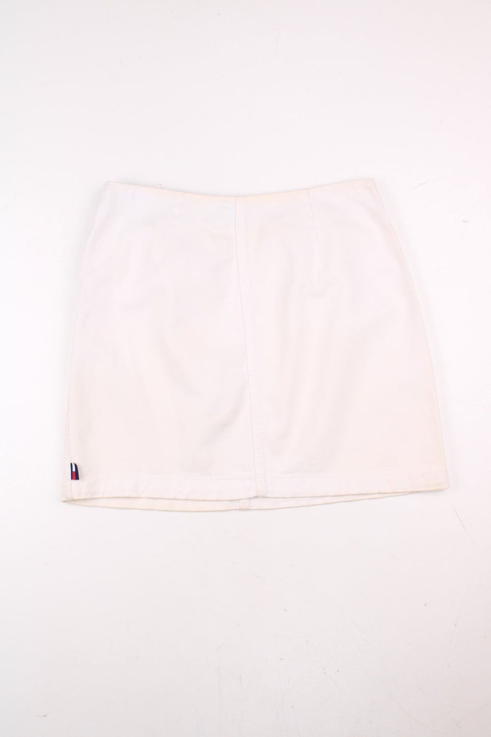 Tommy Hilfiger Mini Skirt in a off white colourway, has zip by the left side and embroidered badge on the back.