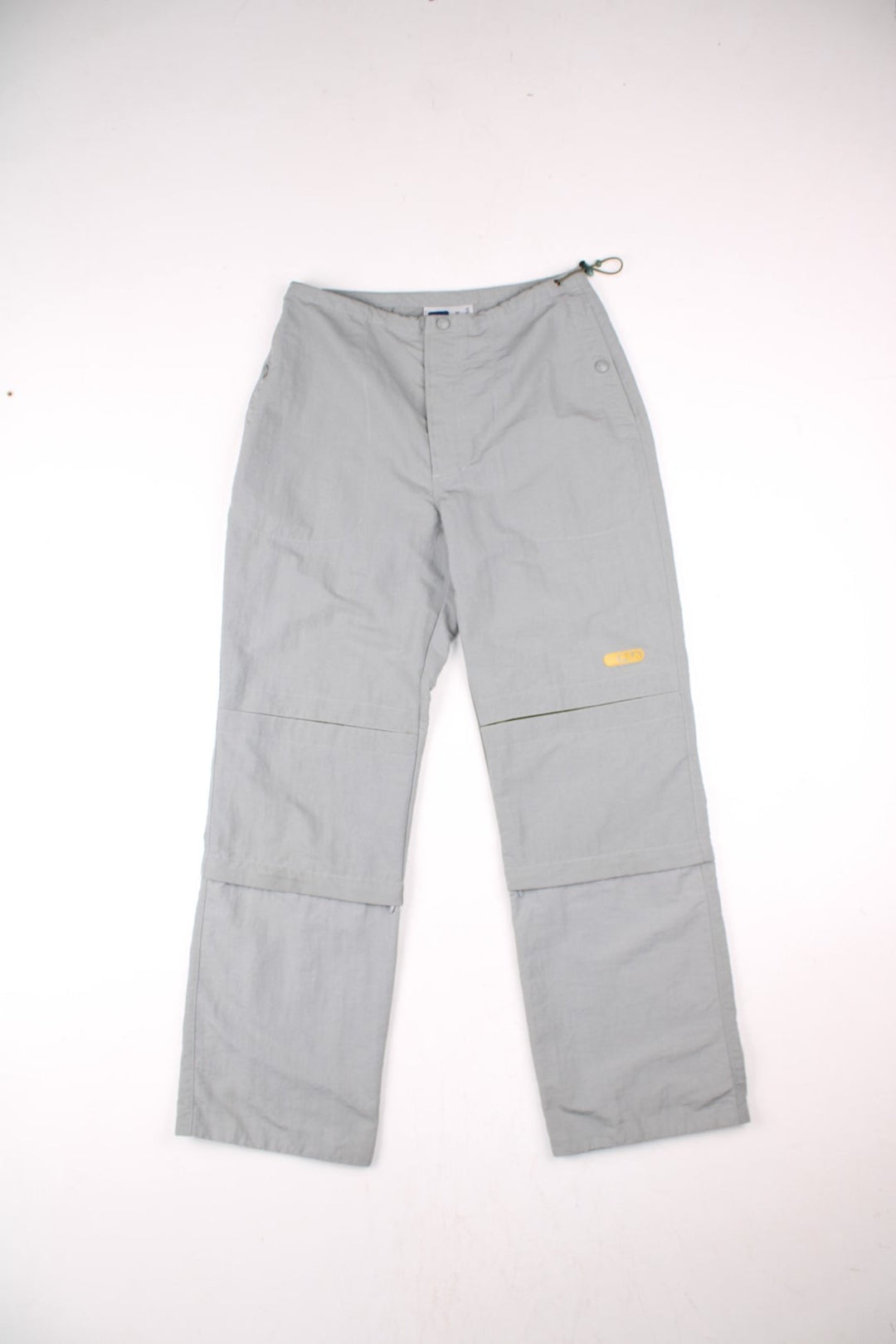 Y2K Fila Cargo Trousers in a grey colourway with big pockets on the front and zip at the bottom for detachable quarter length shorts option, and has the logo embroidered on the front left leg.