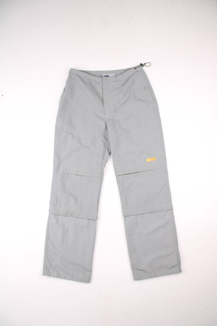 Y2K Fila Cargo Trousers in a grey colourway with big pockets on the front and zip at the bottom for detachable quarter length shorts option, and has the logo embroidered on the front left leg.