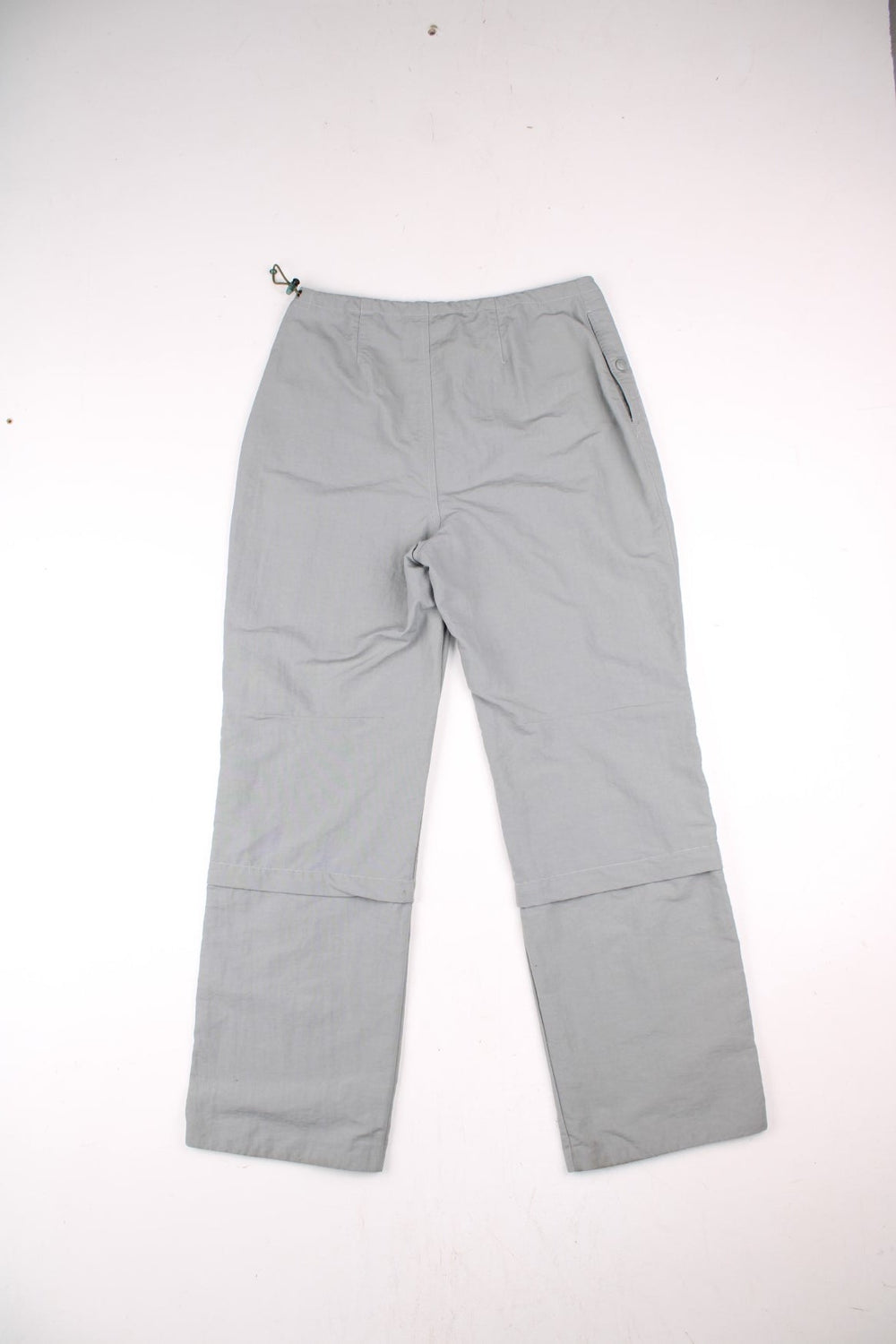 Y2K Fila Cargo Trousers in a grey colourway with big pockets on the front and zip at the bottom for detachable quarter length shorts option, and has the logo embroidered on the front left leg.