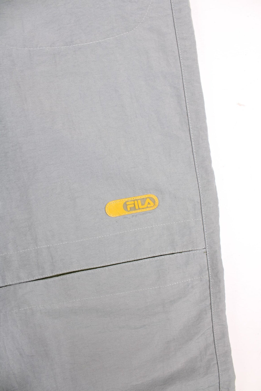 Y2K Fila Cargo Trousers in a grey colourway with big pockets on the front and zip at the bottom for detachable quarter length shorts option, and has the logo embroidered on the front left leg.