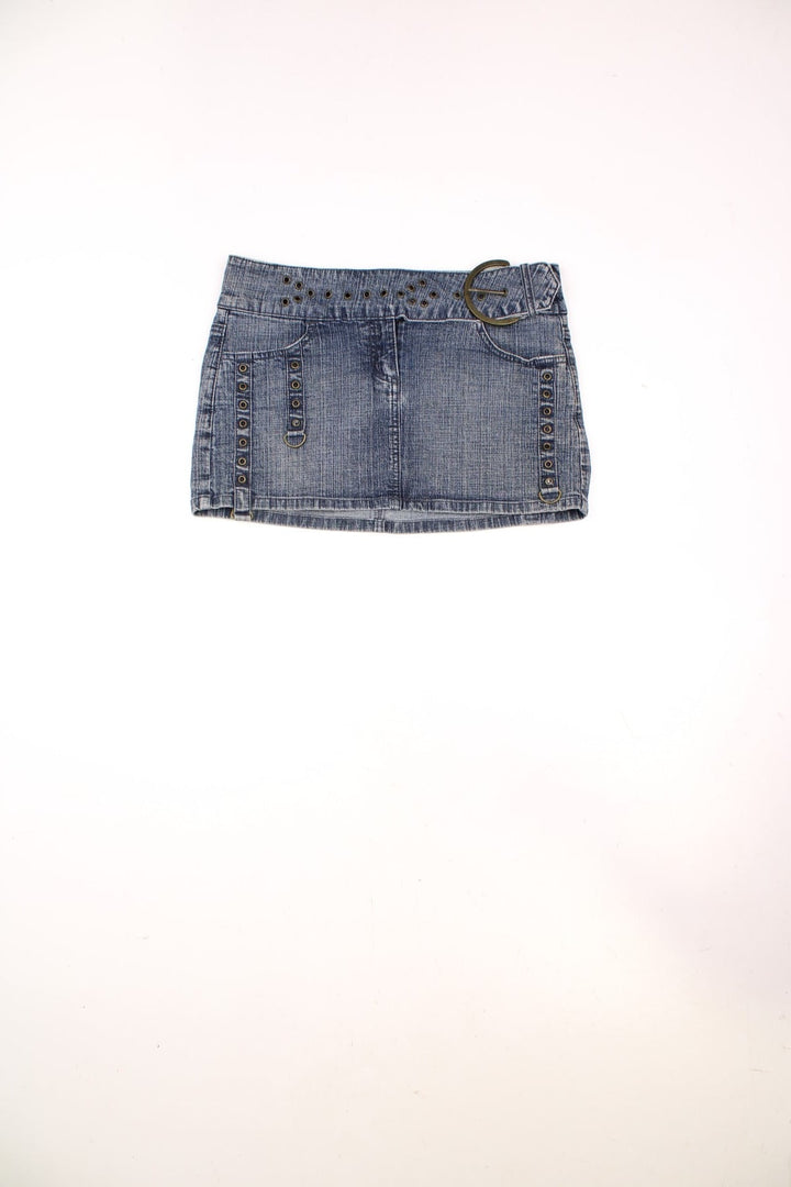 Y2K Moto by Topshop denim mini skirt with zip closure, rivet detailing, front and back pockets, and an attached belt with a large circular buckle. 