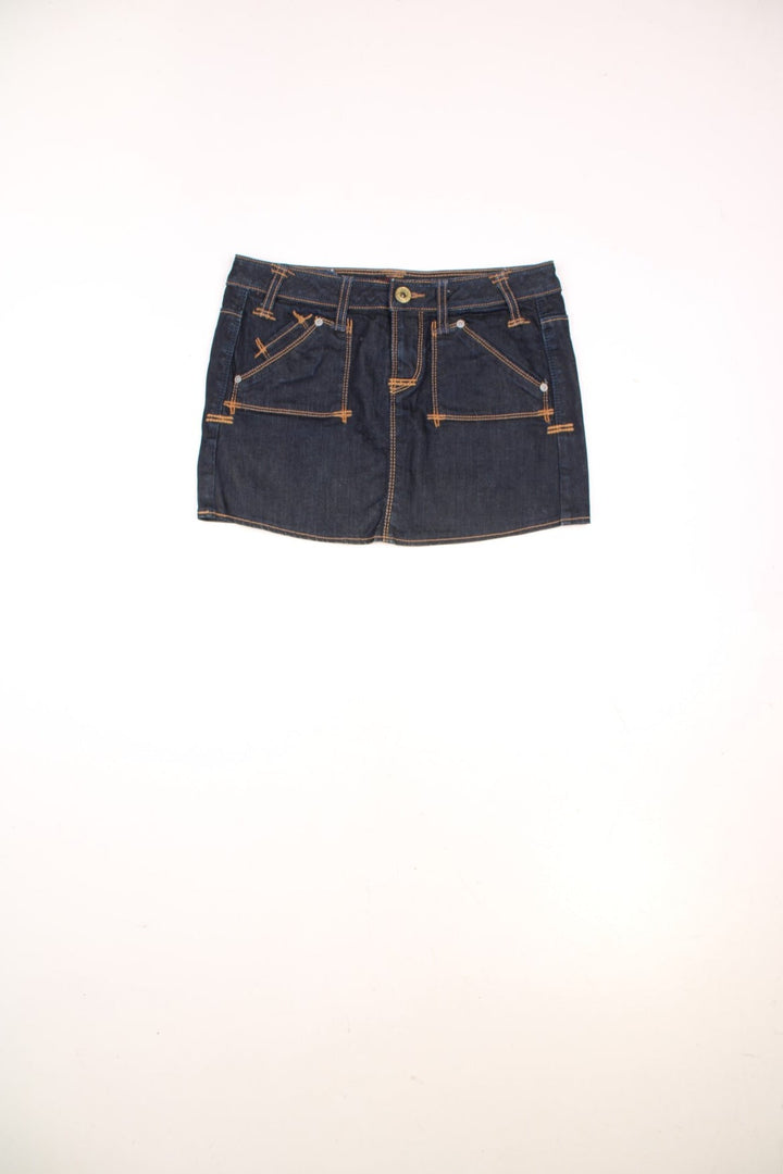 Y2K dark wash denim mini skirt by Guess Premium with zip and button closure, and front and back pockets. 