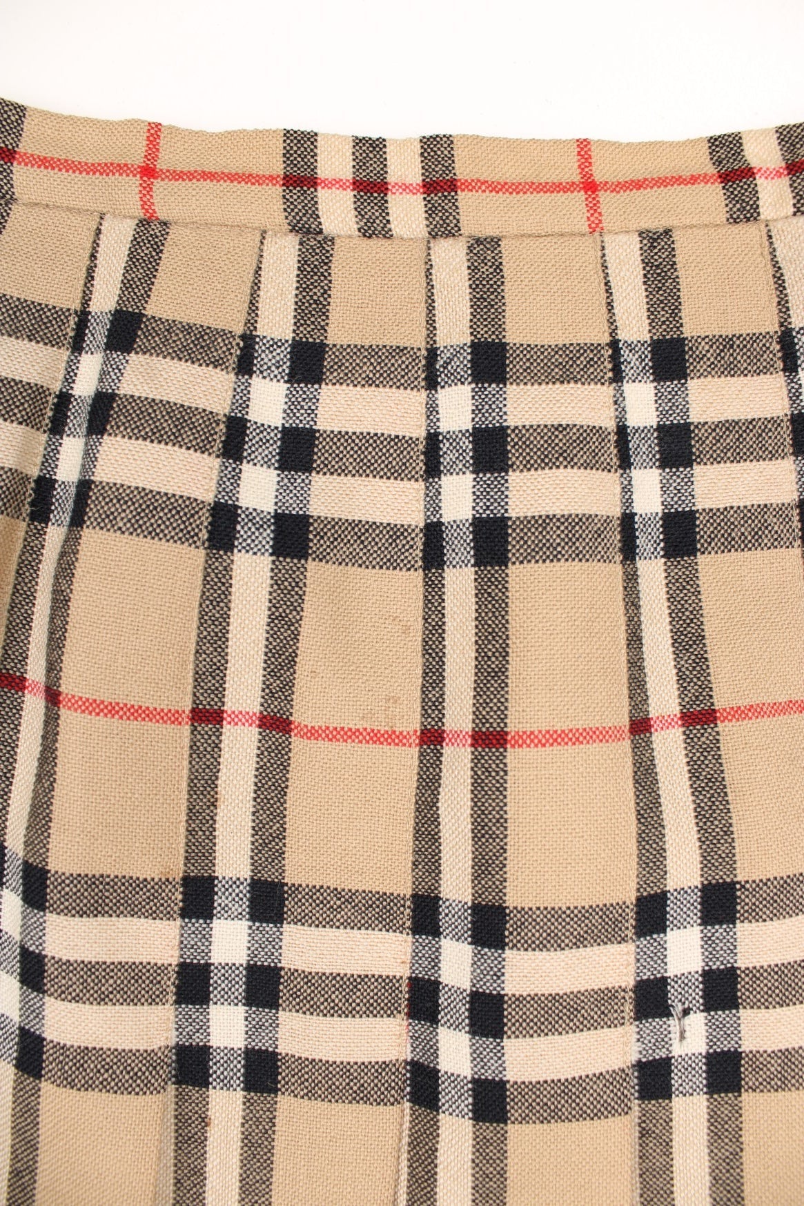 Vintage Burberry (then Burberrys) pleated wool midi skirt in the signature brown, black and red Burberry plaid pattern. Has a metal hook and zip fastening on the side. 