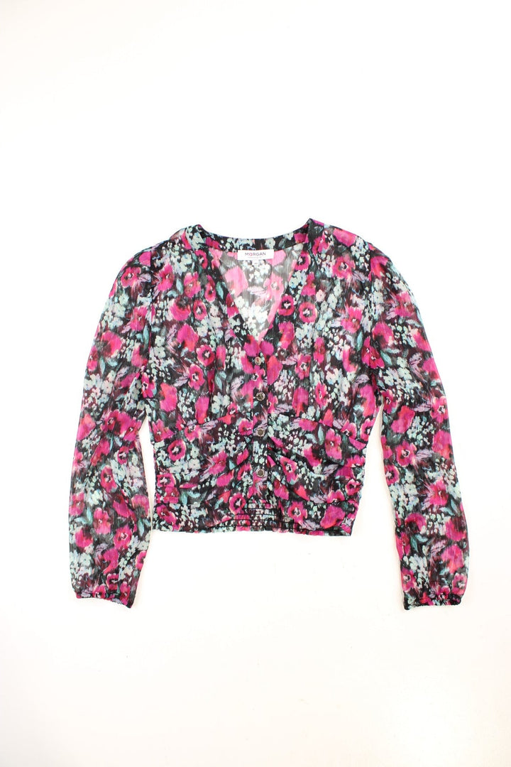 Morgan de Toi blouse in black with a hot pink and blue floral pattern, button closure and shirred hem at the back.