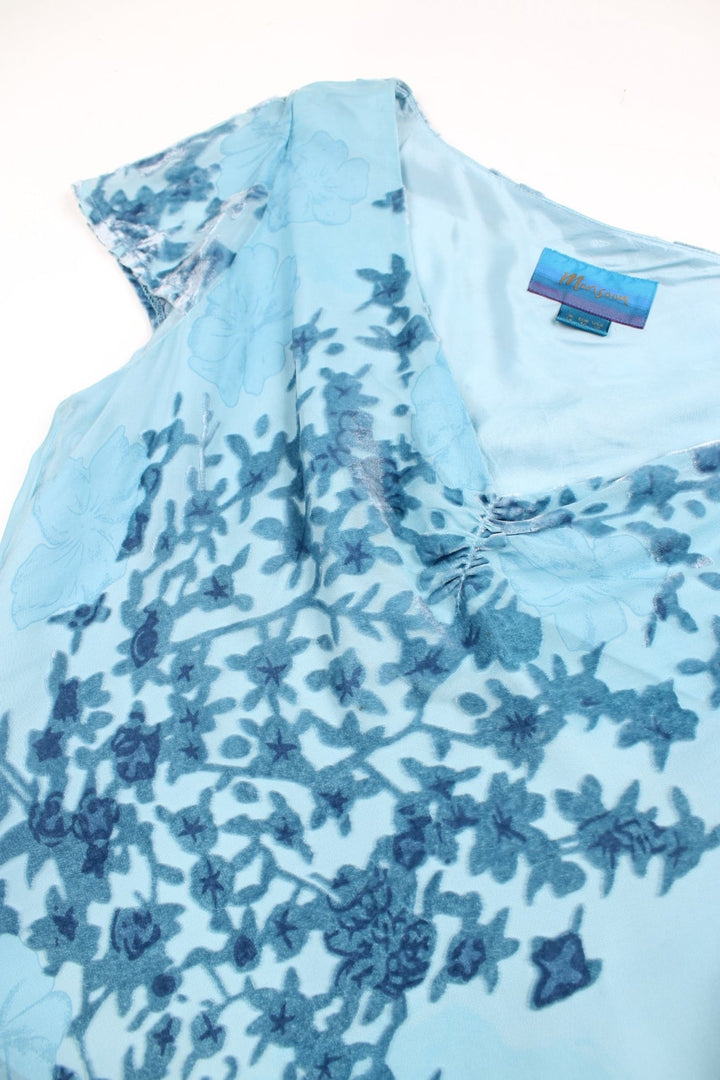 Y2K Monsoon floaty top in blue with cap sleeves, a ruched bust, and velvet floral appliqué.