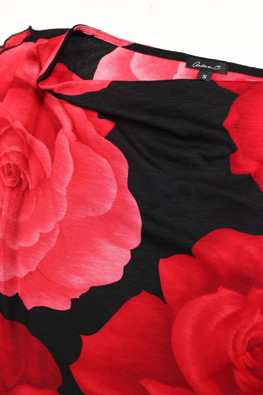 Y2K cowl neck top in red with a large rose print on a black background and split cap sleeves.