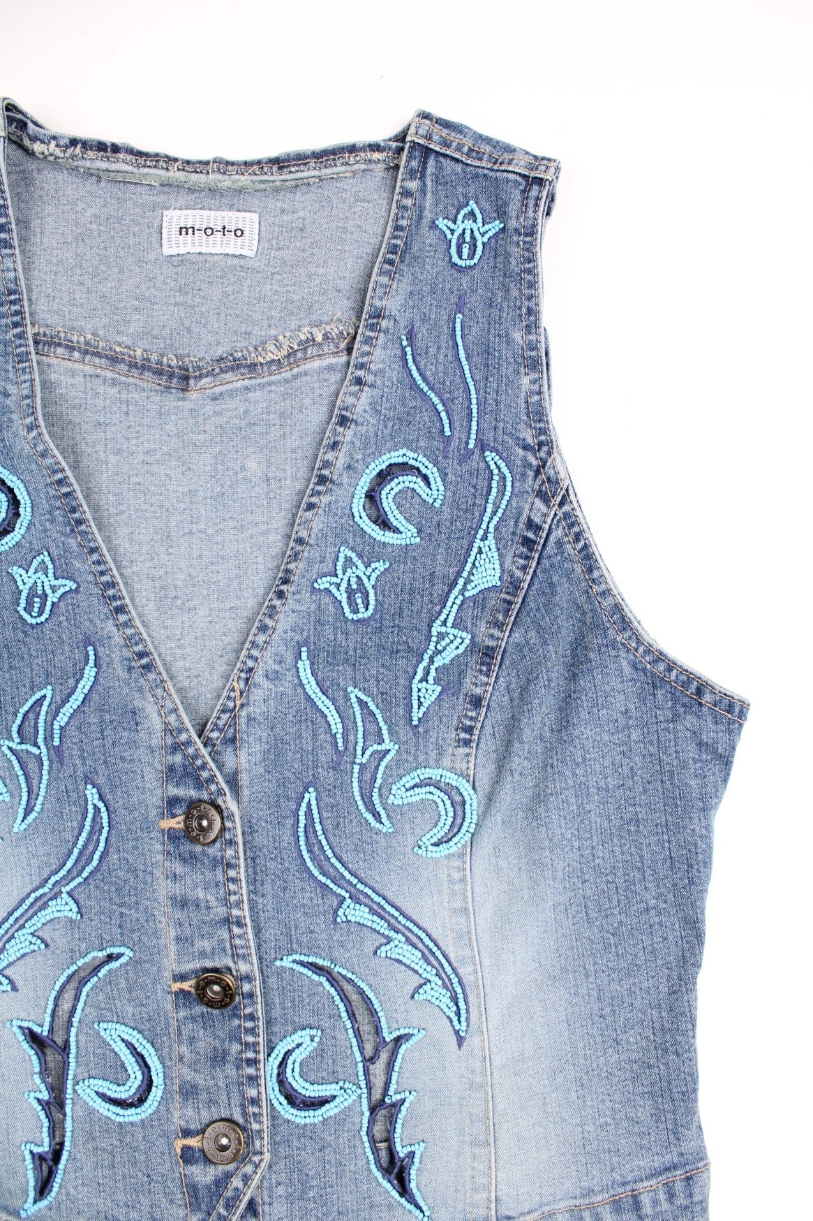 Moto blue denim vest top with cutouts and blue beaded designs on the front. Matching beaded denim skirt available. 