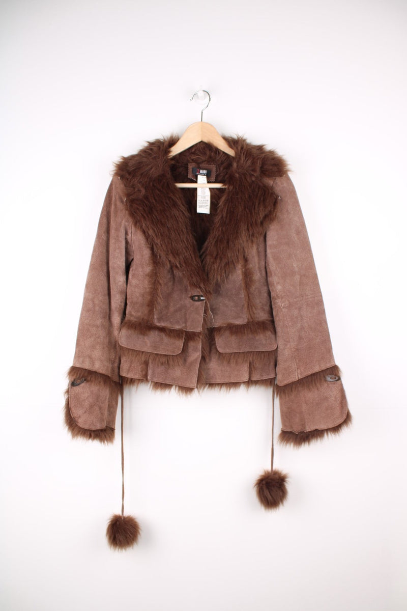 Morgan De Toi Afghan Coat in a brown colourway, leather shell with a faux fur lining, singular button up and also has a pompom belt.