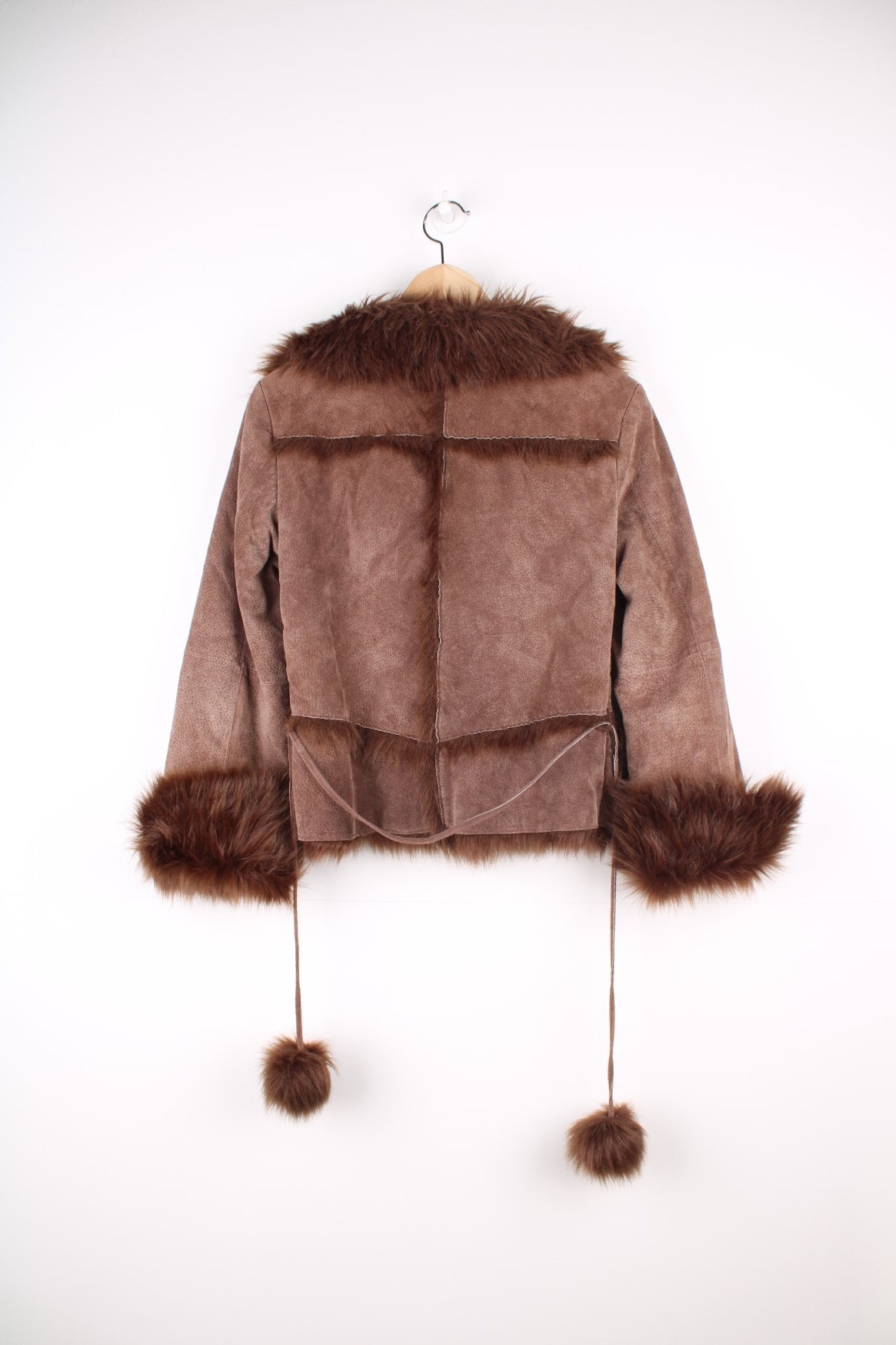 Morgan De Toi Afghan Coat in a brown colourway, leather shell with a faux fur lining, singular button up and also has a pompom belt.