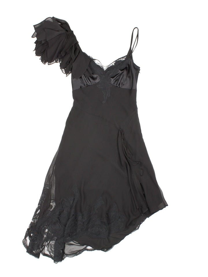 Y2K Karen Millen silk strappy midi dress in black with lace detailing around the bust and asymmetrical hem, and a large applique flower at the shoulder.