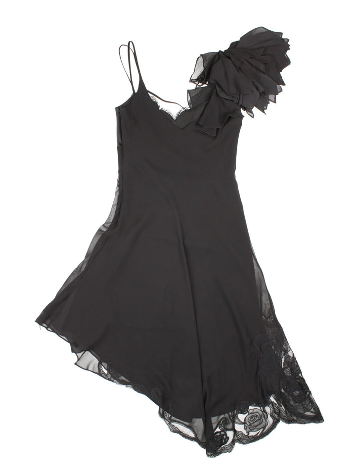 Y2K Karen Millen silk strappy midi dress in black with lace detailing around the bust and asymmetrical hem, and a large applique flower at the shoulder.