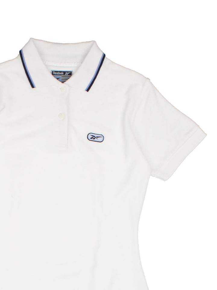 Y2K Reebok polo mini dress in white with blue stripe detailing at the collar, two buttons at the neck, and embroidered logos on the chest and back.