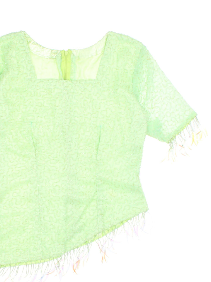 Y2K beaded top in pale green with an asymmetrical hem, beading throughout and zip closure.