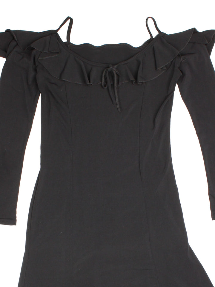 Y2K maxi dress in black with ruffle detailing, a small bow in the front, and an asymmetrical hem.