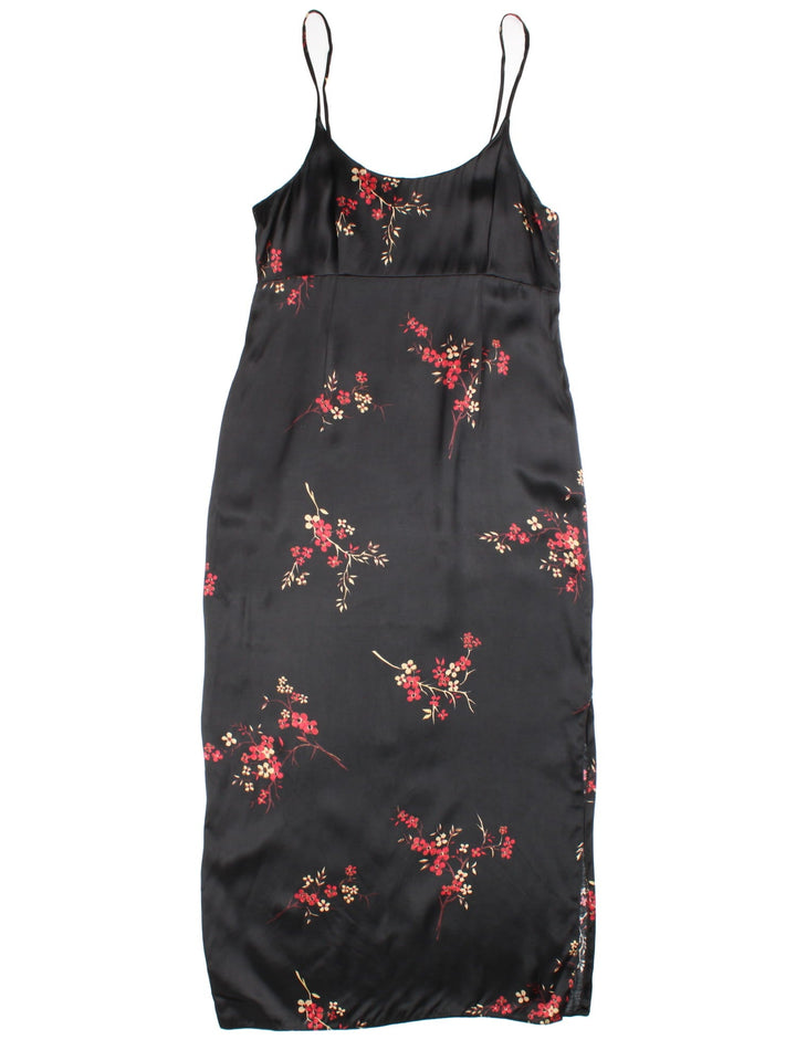 Vintage New Look floral maxi dress in a black colourway with cherry blossom floral print thoughout. The dress has an empire line waist, split up the side and zip on the back to close.