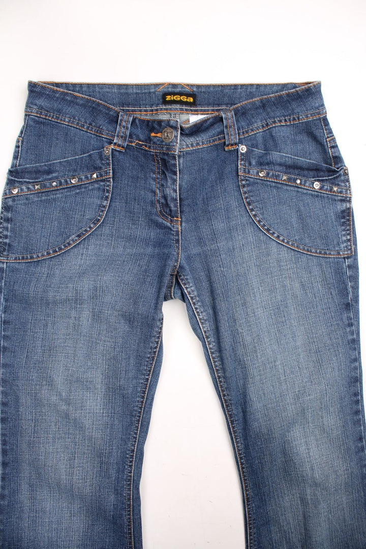  Flared Zigga jeans in dark  denim colourway, has pockets with studs embroidered on and contrast stitching on the back pockets.