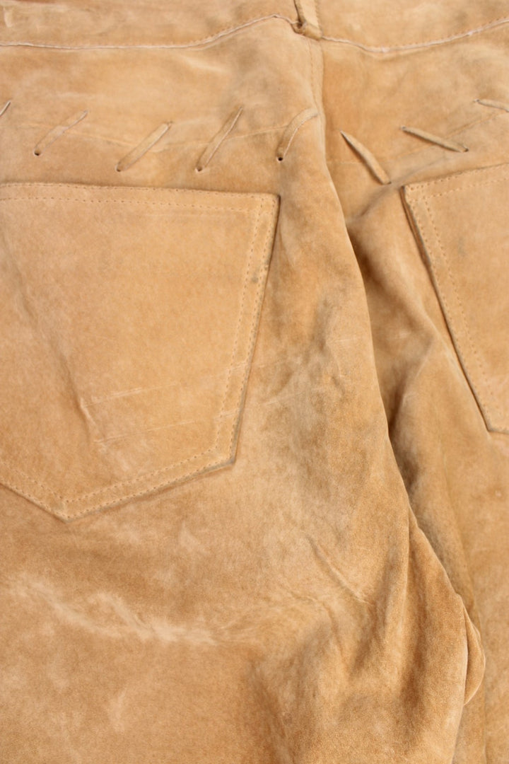  Western Leather Trousers in a  brown colourway with multiple pockets, and has cross stitching tassels down the side of the legs and round the back.