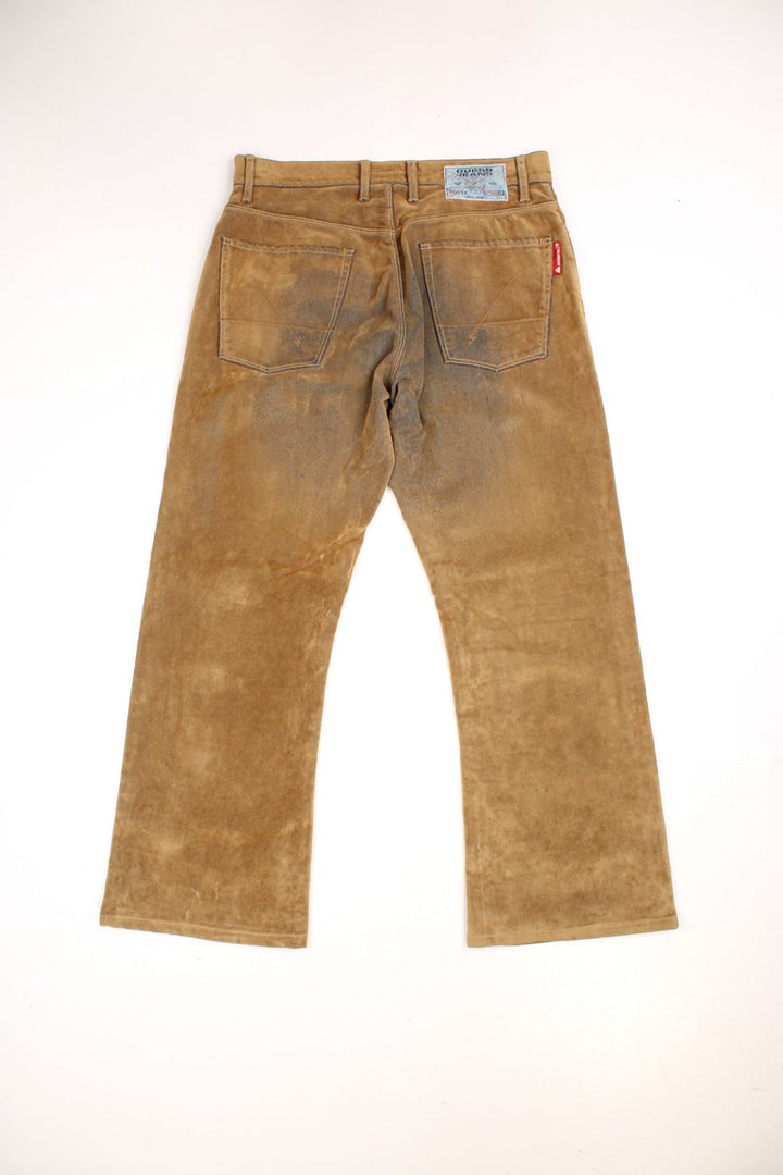 Y2K  Distressed Trousers in  colourway, material similar to suede, has pockets and the logo embroidered on the back.