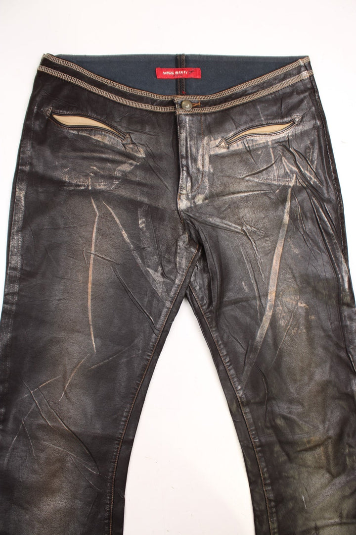 Y2K  Flared Pleather Trousers in  colourway with pockets, low rise, and has the logo embroidered on the back.