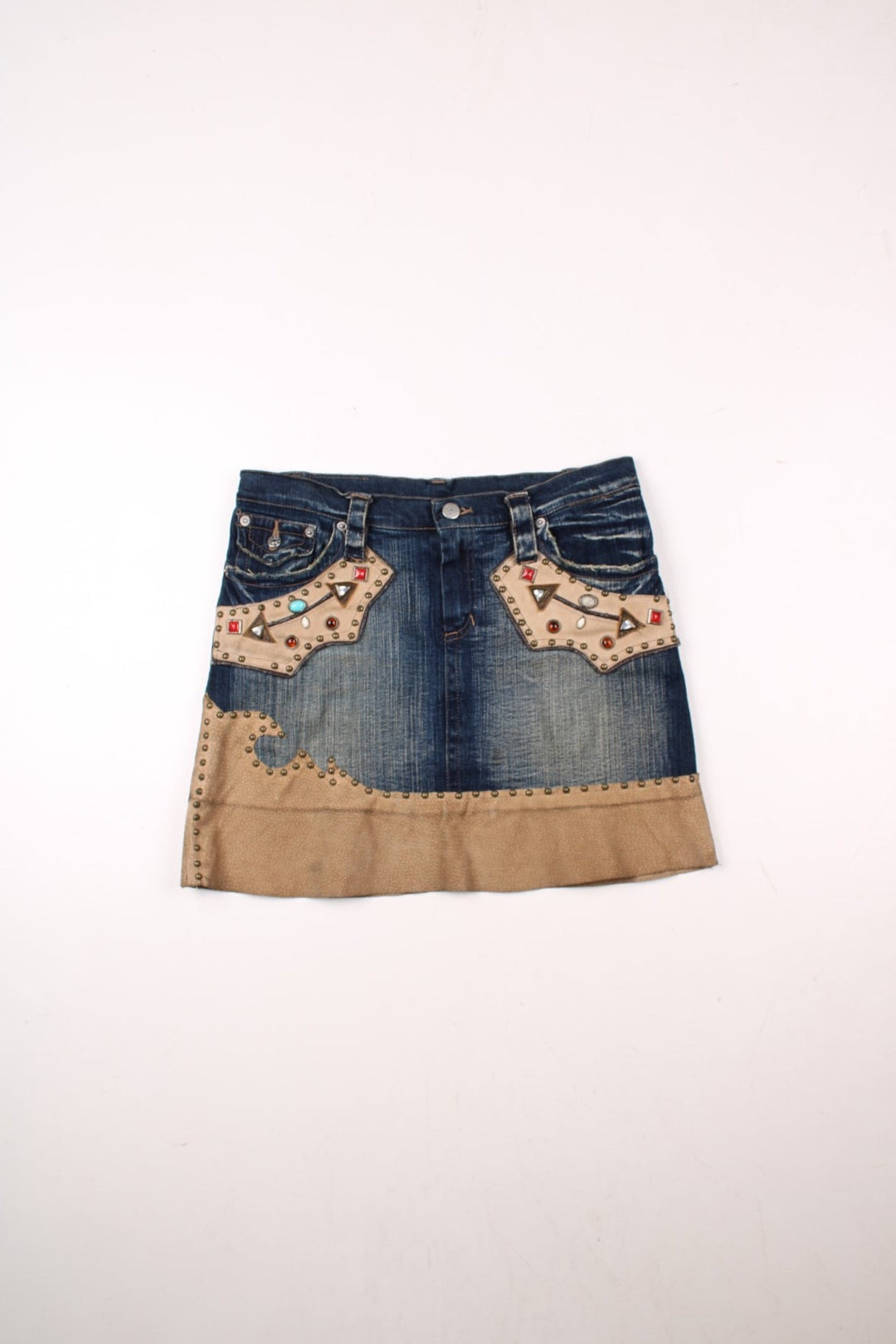 Y2K embellished denim mini skirt in blue with faux suede patches, zip and button closure, and four pockets by AMN&SIA Paris.