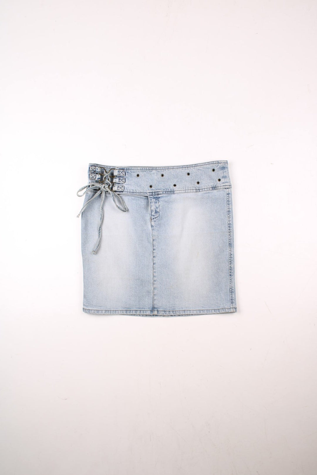 Y2K Armani Jeans denim mini skirt in a light blue wash with concealed zip and button closure, an attaced lace-up belt, and eyelet detailing around the waist .