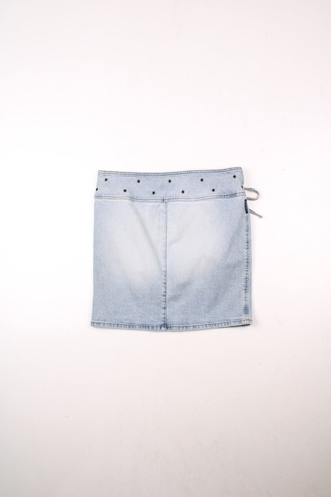 Y2K Armani Jeans denim mini skirt in a light blue wash with concealed zip and button closure, an attaced lace-up belt, and eyelet detailing around the waist .