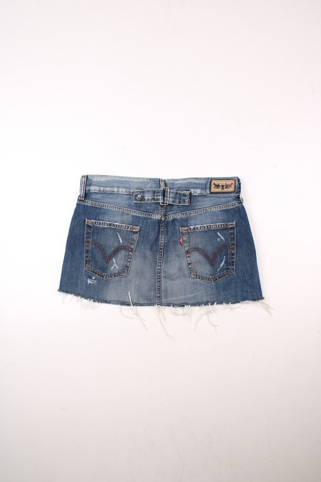 Y2K Levi Strauss denim mini skirt in blue with zip and button closure, four pockets, a raw hem and distressing to pockets, a buckle tightener in the back and a Levi's cowboy patch.