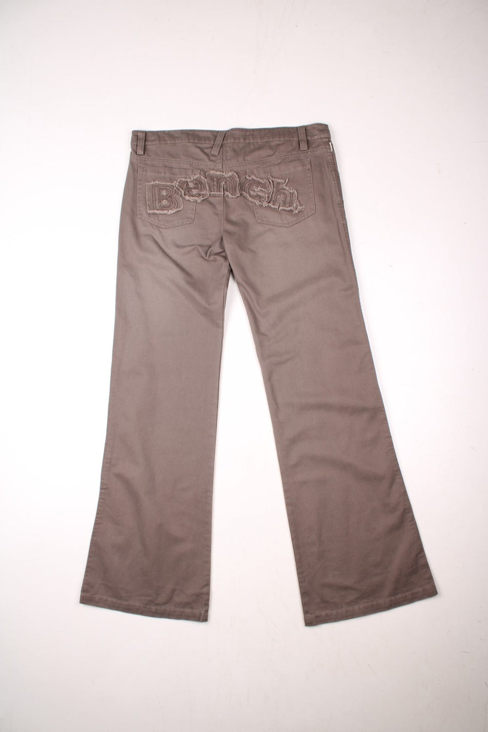 Bench straight leg lightweight trousers in brown with zip and button closure, four pockets, and a distressed embroidered spellout across the back..