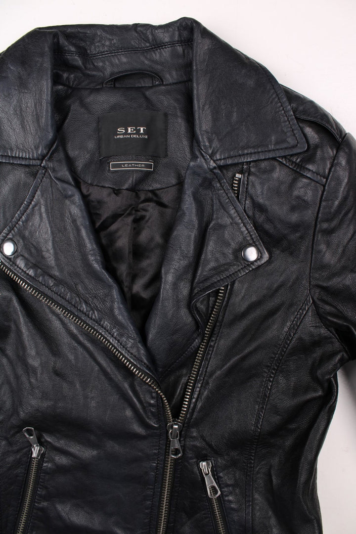 Y2K SET Urban Deluxe real leather jacket in black with two pockets, zip closure, side adjusters, and a raised chevron design on the back.