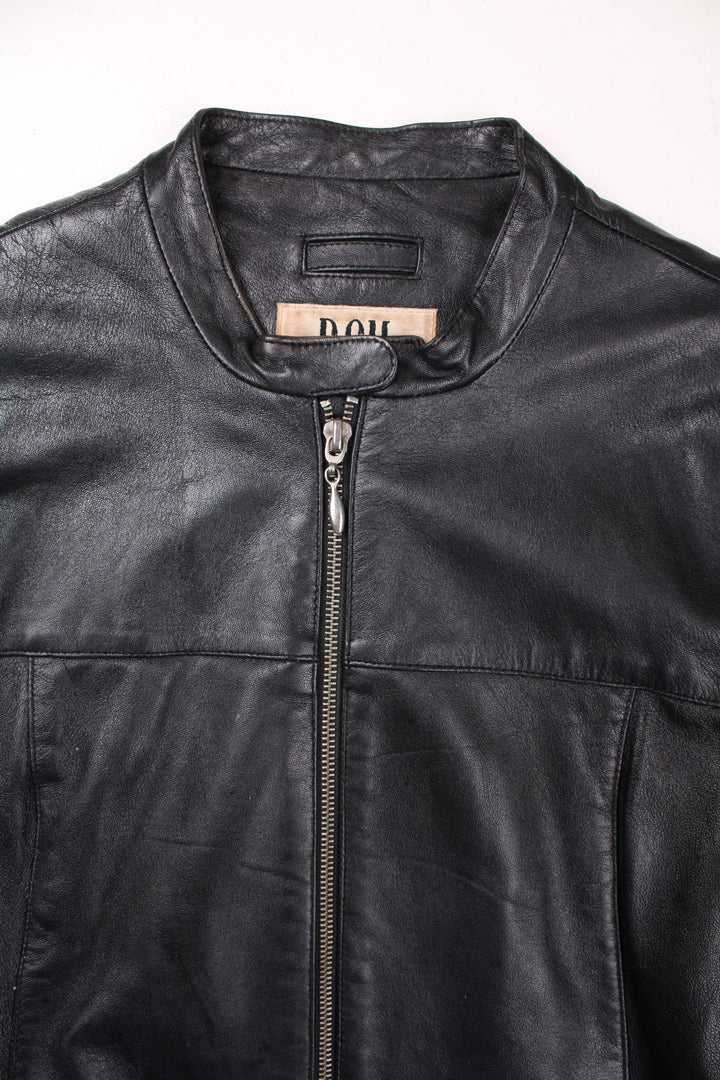 Y2K Bay collarless real leather jacket in black with two pockets and zip and snap closure.