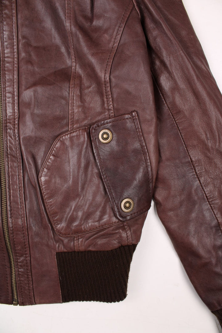 Y2K Oasis real leather jacket in brown with zip closure, two snapped pockets, and a ribbed collar, cuffs, and hem.