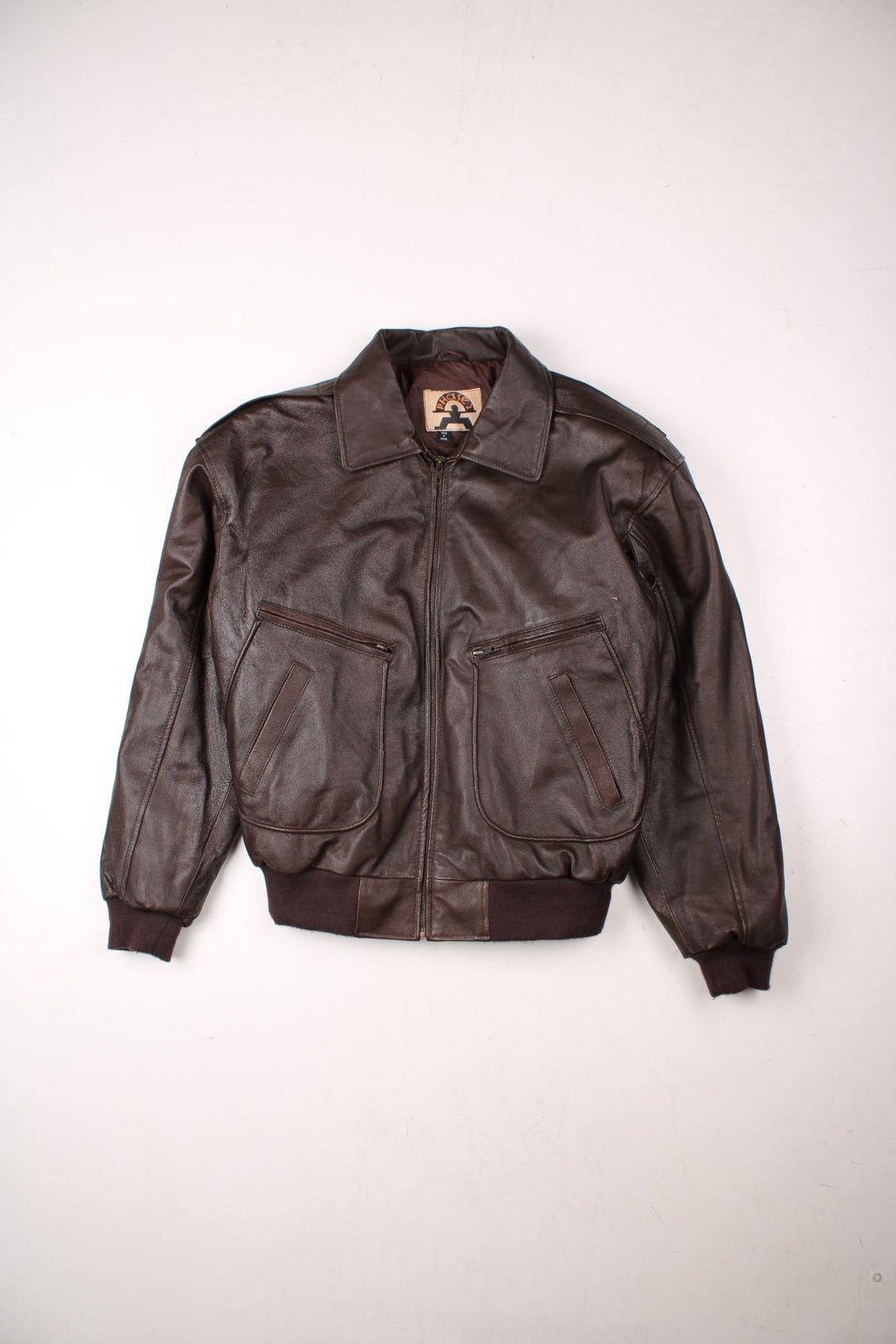 Y2K Phase 2 leather jacket in dark brown with ribbed hem and cuffs, multiple pockets, zip closure, and epaulets.