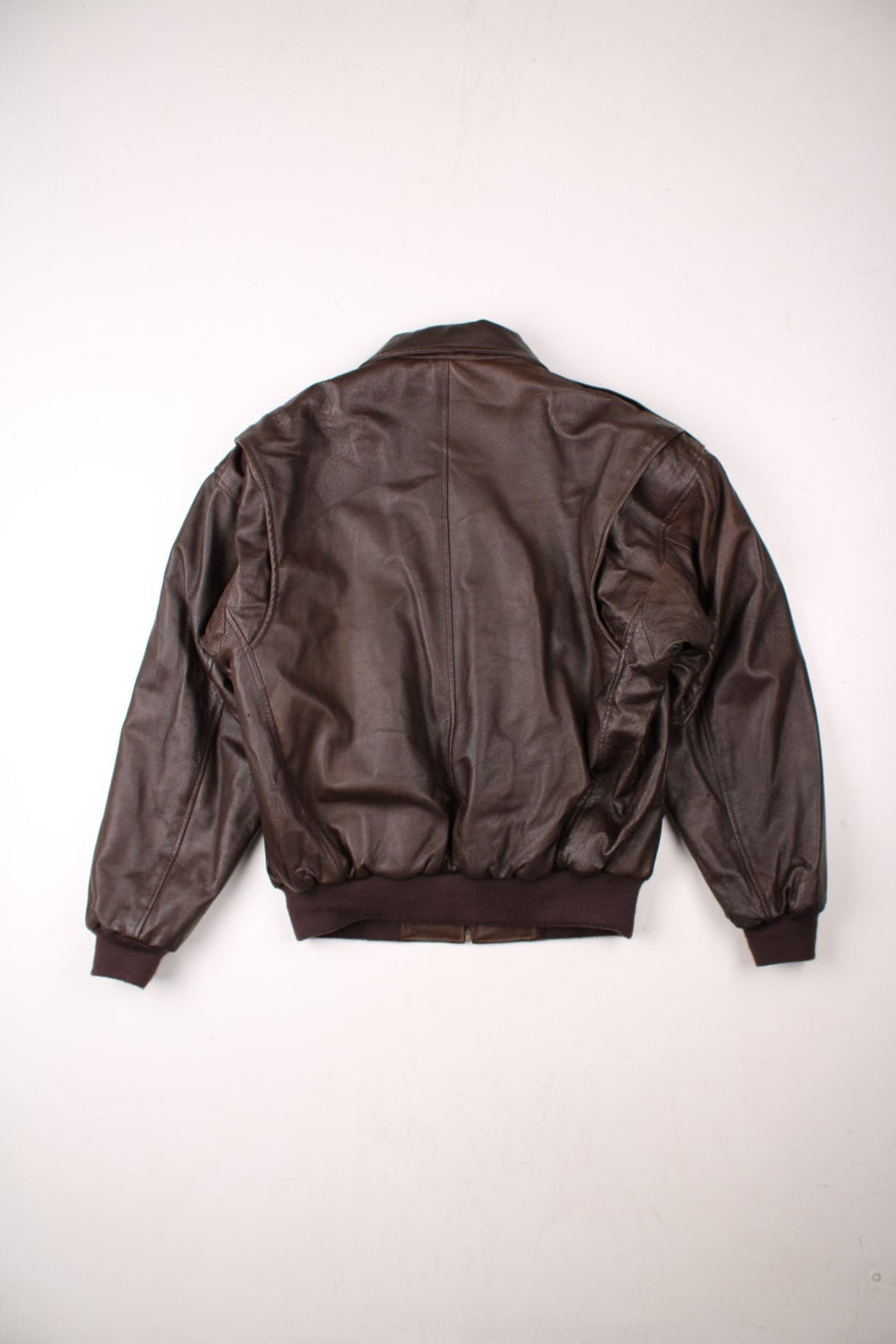 Y2K Phase 2 leather jacket in dark brown with ribbed hem and cuffs, multiple pockets, zip closure, and epaulets.