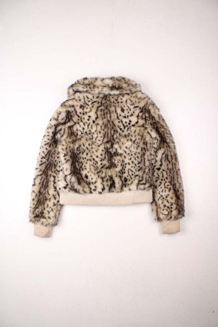 Y2K faux fur cropped jacket in tan with ribbed cuffs and hem, two pockets and zip closure by Honee.