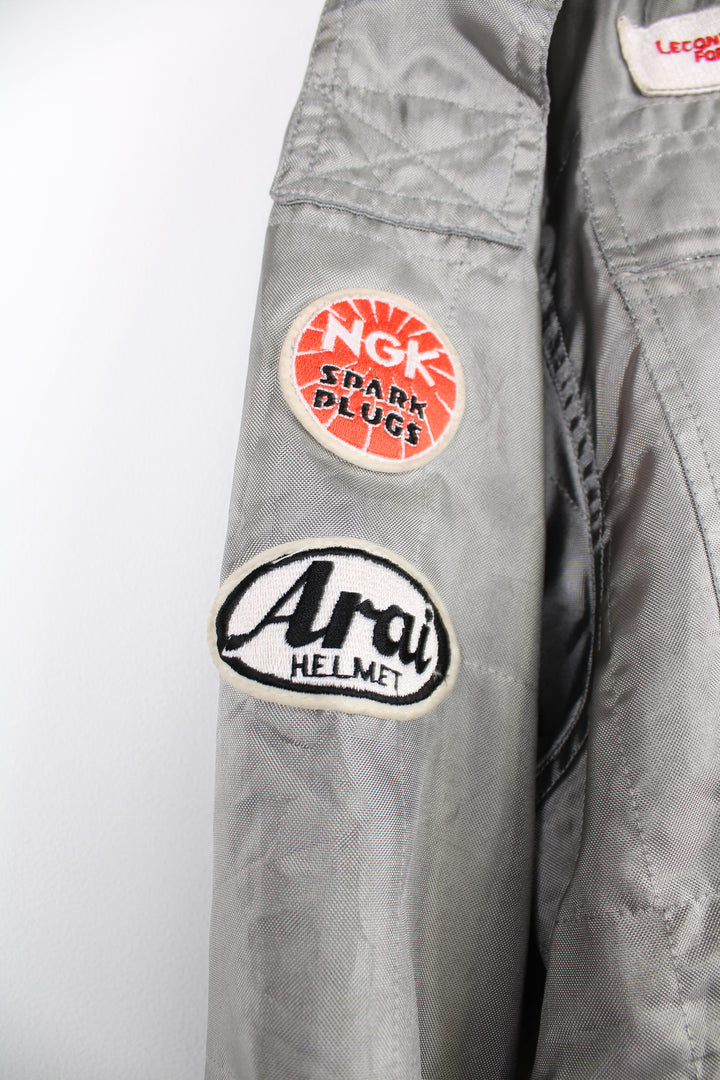 Vintage Alpha Cubic nylon bomber style formula 1 racing jacket in grey, features all over embroidered badges/patches and full zip