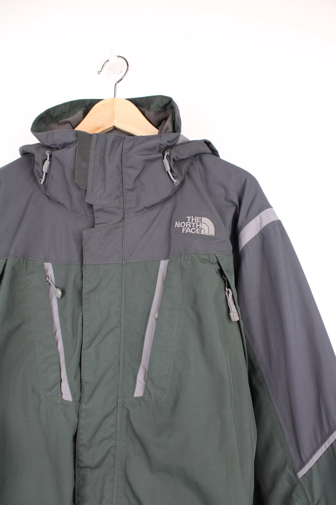 Green and grey The North Face ski jacket. Features embroidered logo on the chest, removable hood, chest and sleeve pockets, inside pockets and snow skirt.