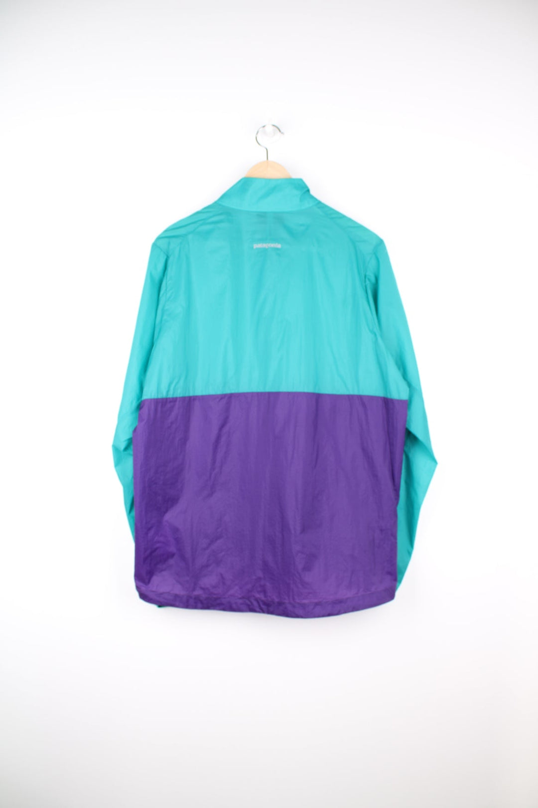 Green and purple Patagonia pullover windbreaker jacket. Features printed logo on the chest and popper fastenings.