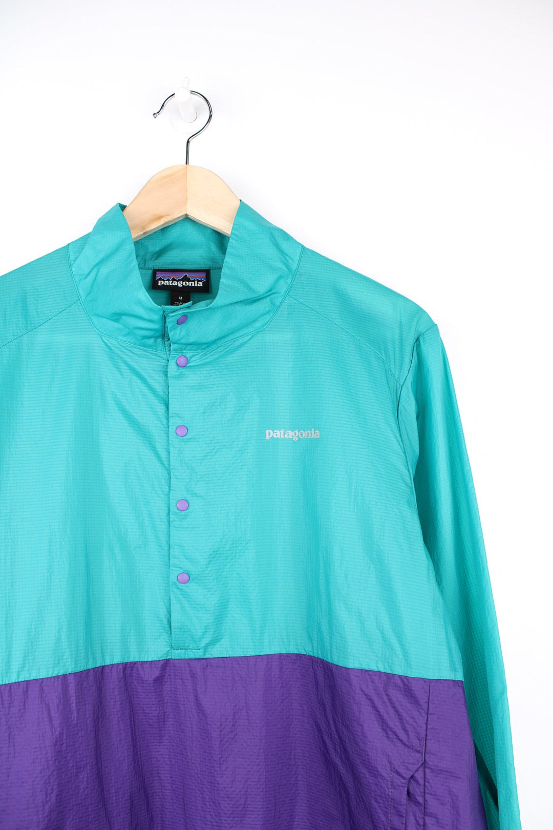 Green and purple Patagonia pullover windbreaker jacket. Features printed logo on the chest and popper fastenings.