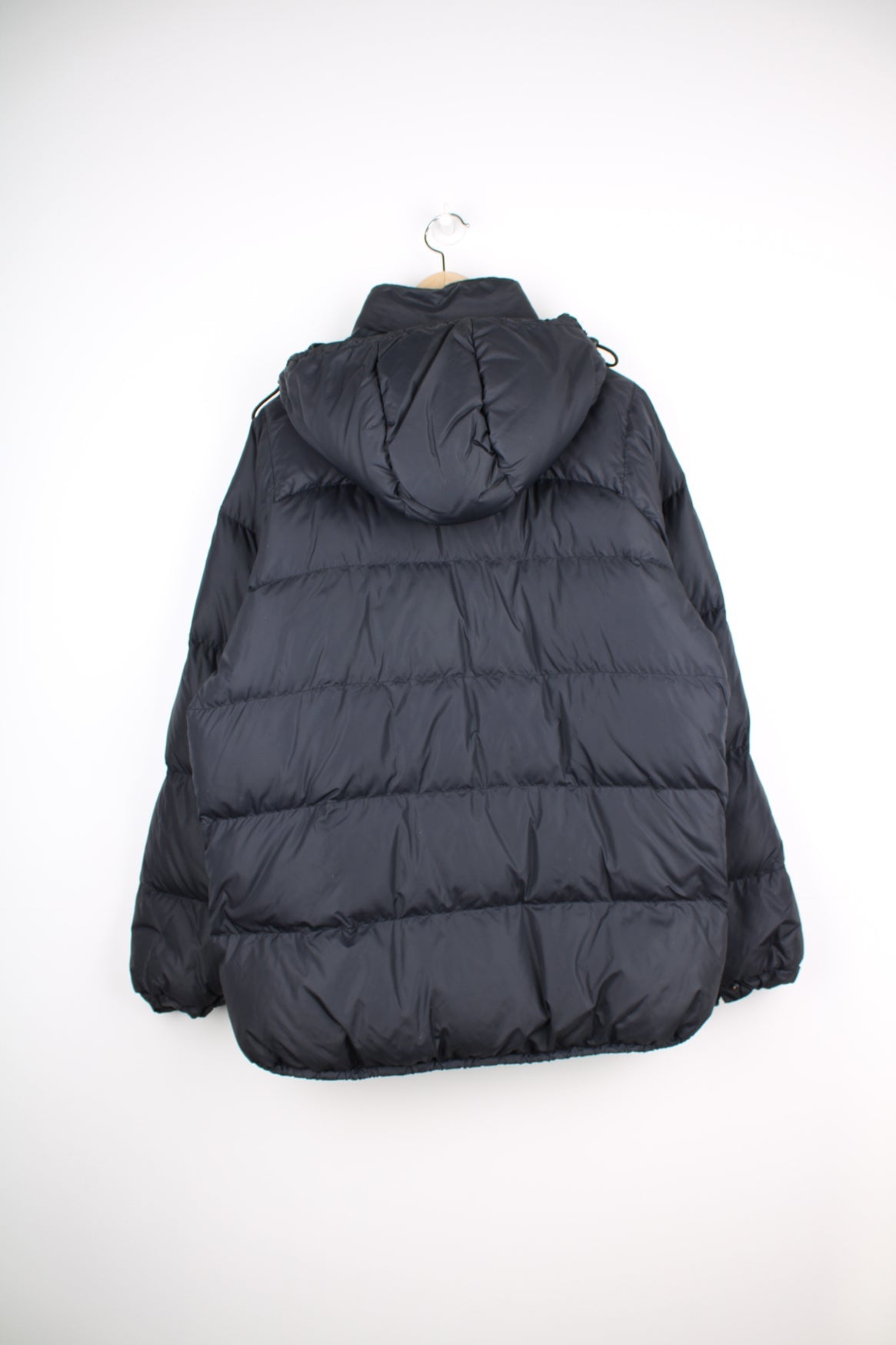 Rab puffer coat in black featuring embroidered logo on the chest.