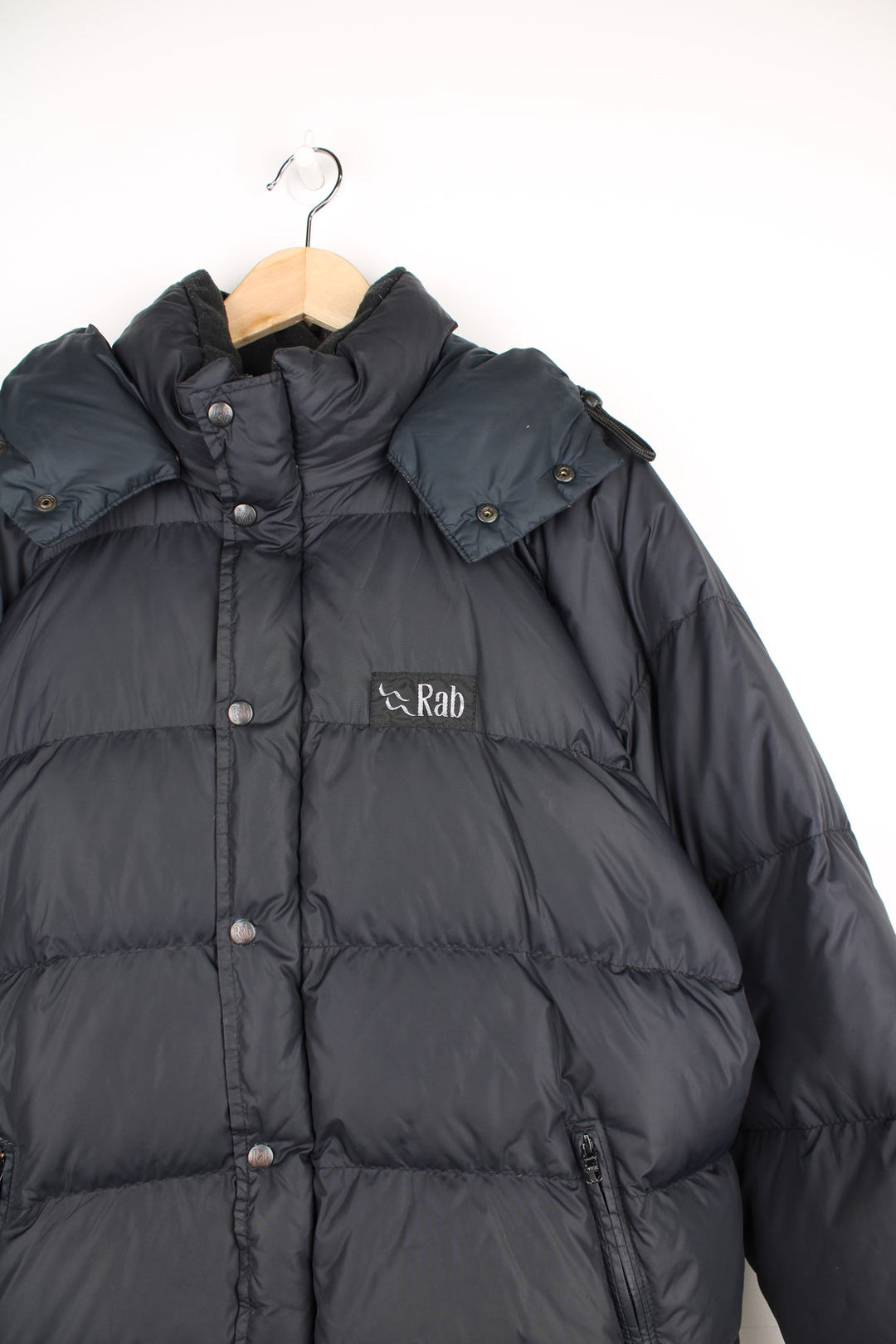 Rab puffer coat in black featuring embroidered logo on the chest.