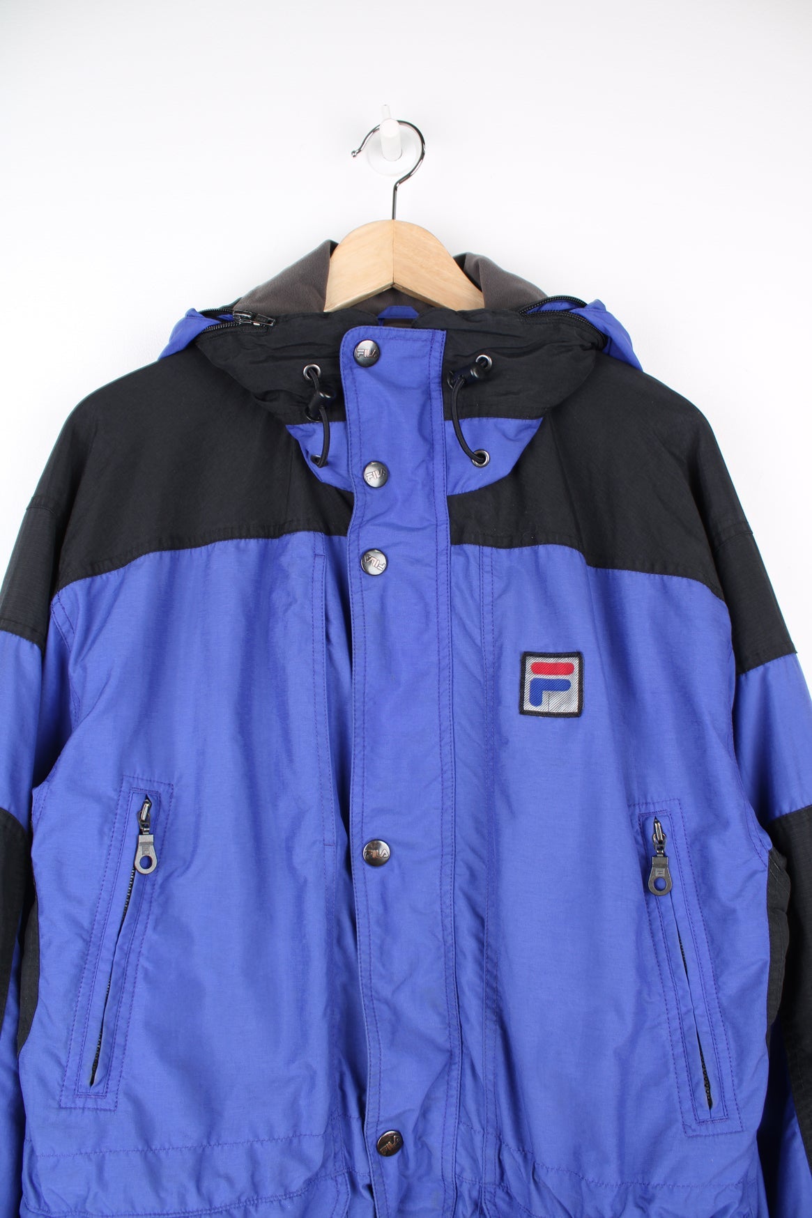 Vintage Fila "Alpine" coat. Features multiple pockets, embroidered logo on the chest and fold away hood.