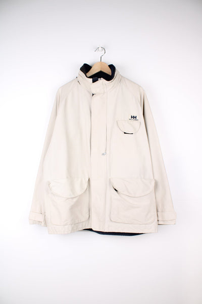 Vintage Helly Hansen beige jacket featuring embroidered logo on the chest and multiple pockets. 