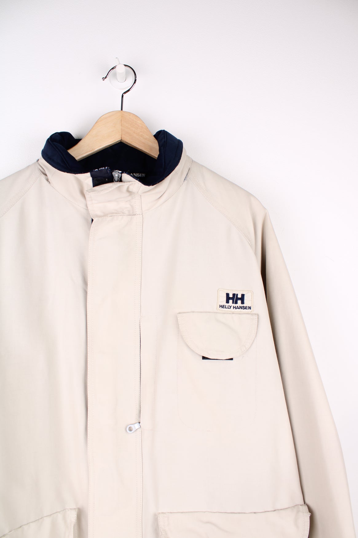 Vintage Helly Hansen beige jacket featuring embroidered logo on the chest and multiple pockets. 